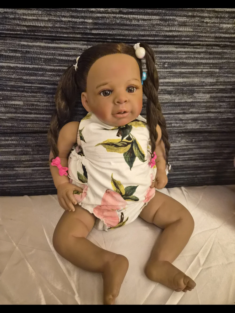 Reborn brown baby doll with pink and white floral outfit
